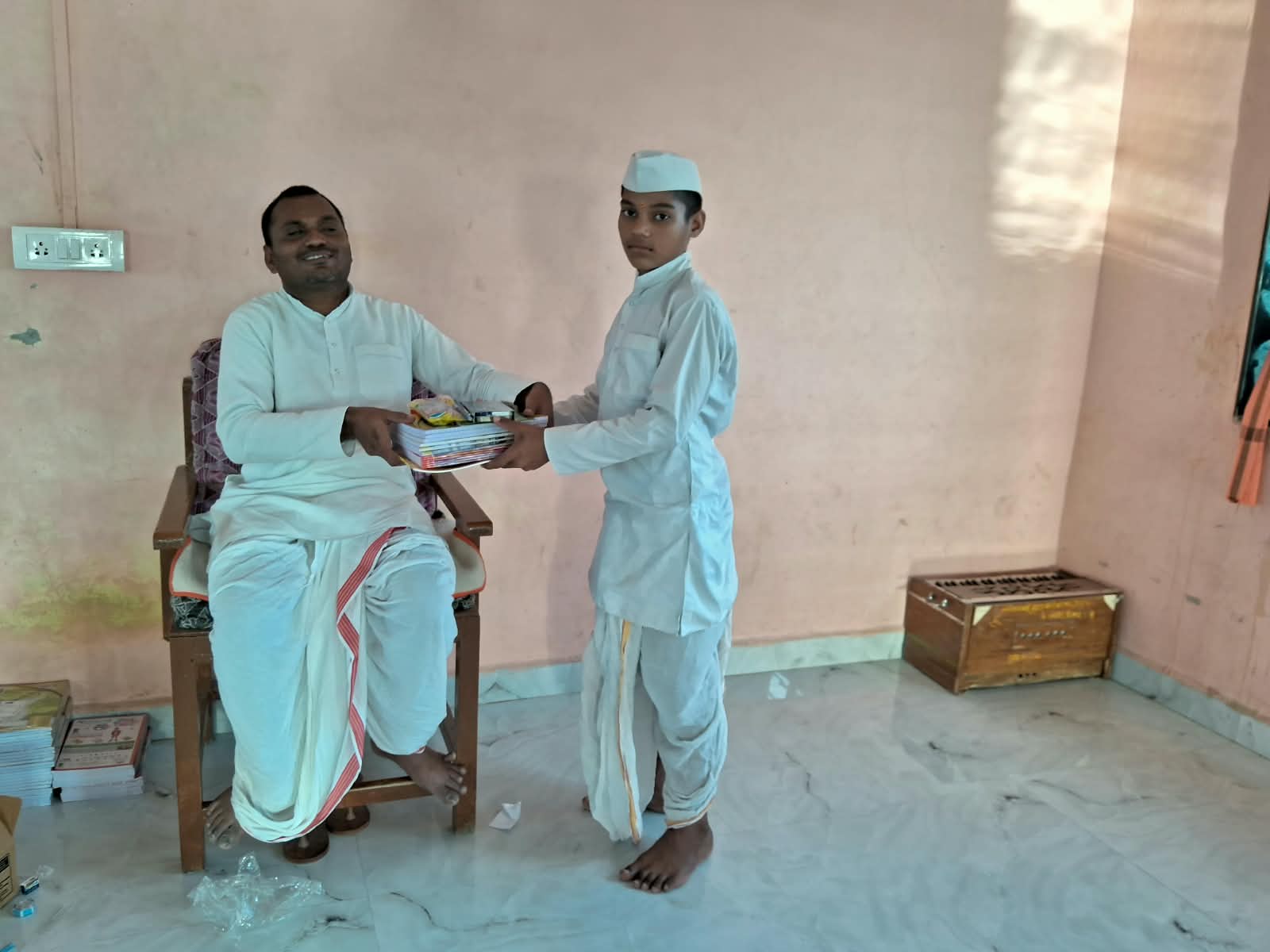 Teacher handing books to a student