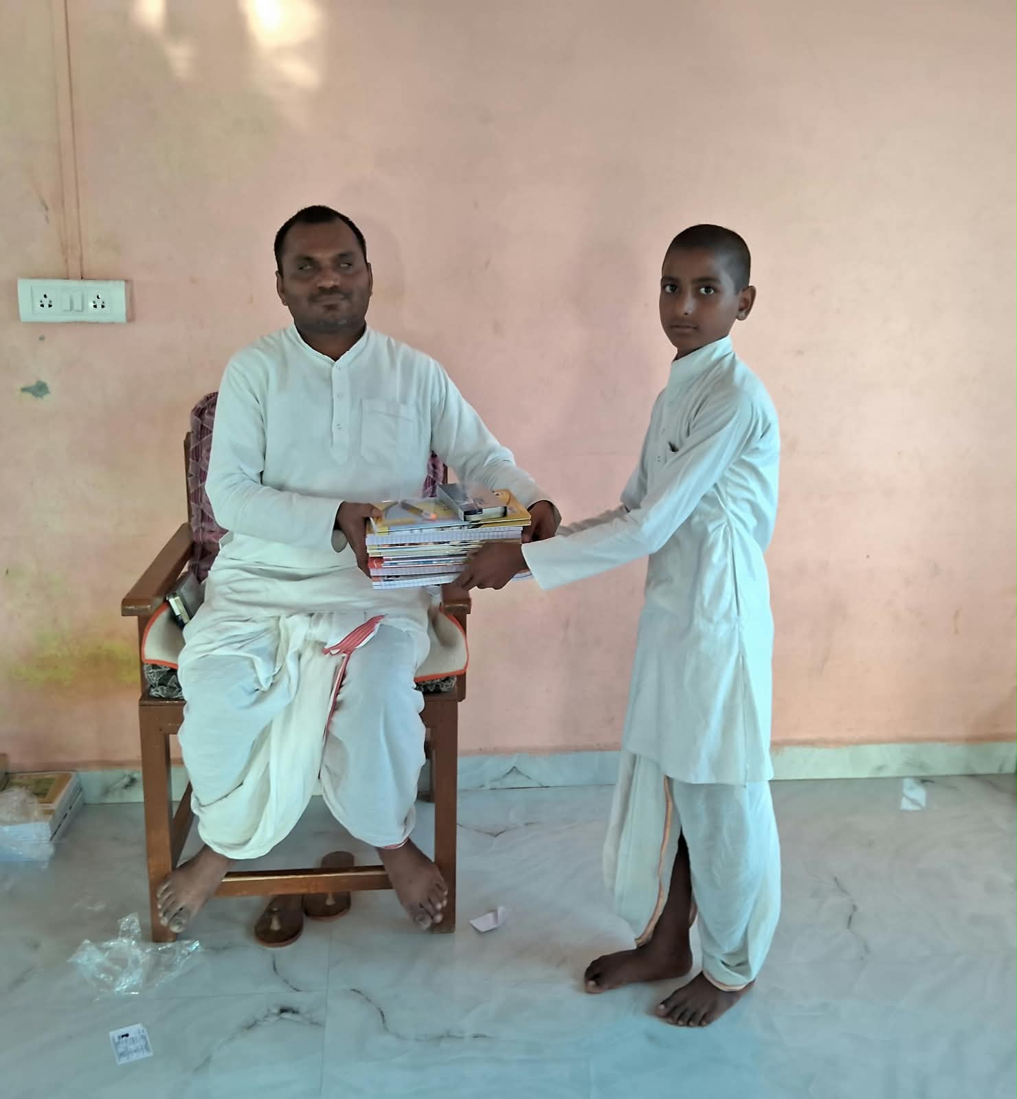 Teacher giving books to a student